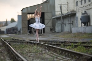 Ballerina posing on the intersection of railway rails. Choosing KPIs to keep your organisation on the rails is boring but critical